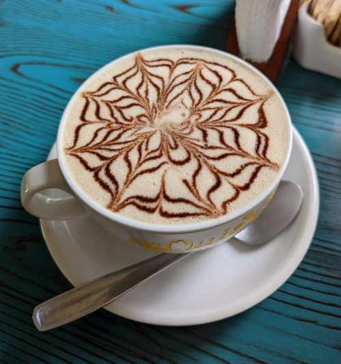 A chai latte with a design on the top. 