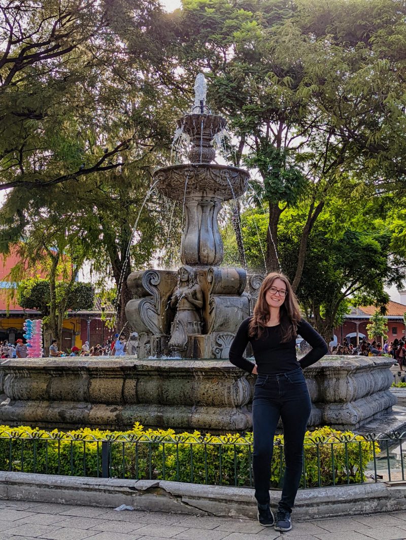 Jessica standing in front of the fountain in Antigua Central Park. 