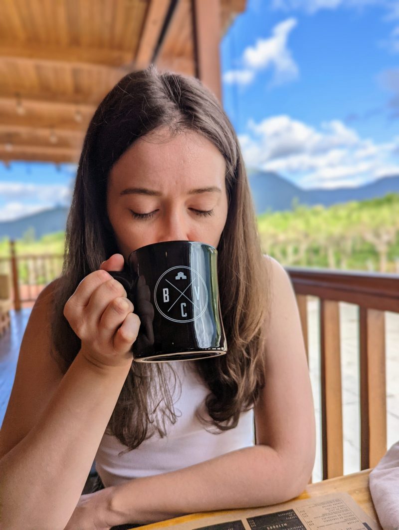 Picture of Jessica drink out of a black mug. 