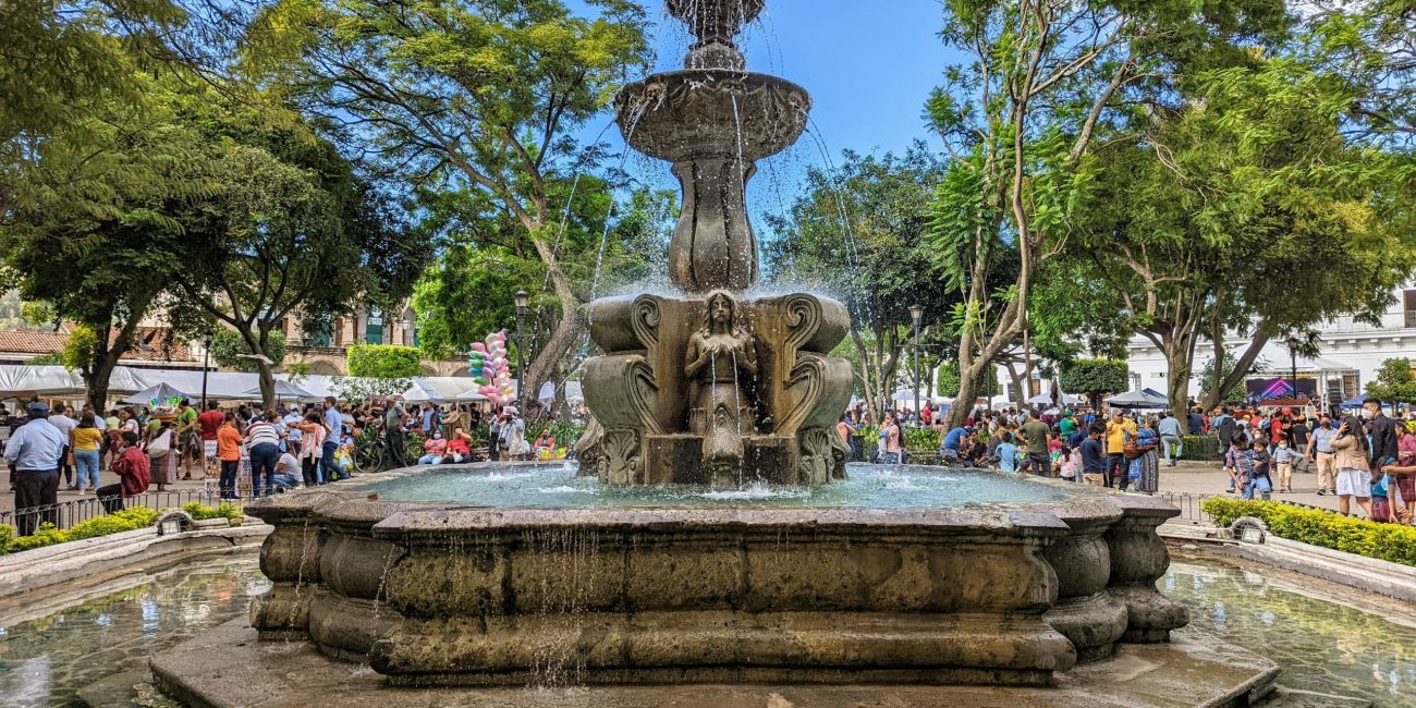 Picture of the fountain in Antigua Central Park. People are seen in the background.